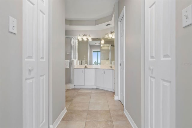 bathroom featuring tile patterned flooring, vanity, and a shower with shower door