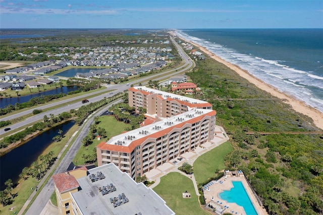 birds eye view of property with a water view and a beach view