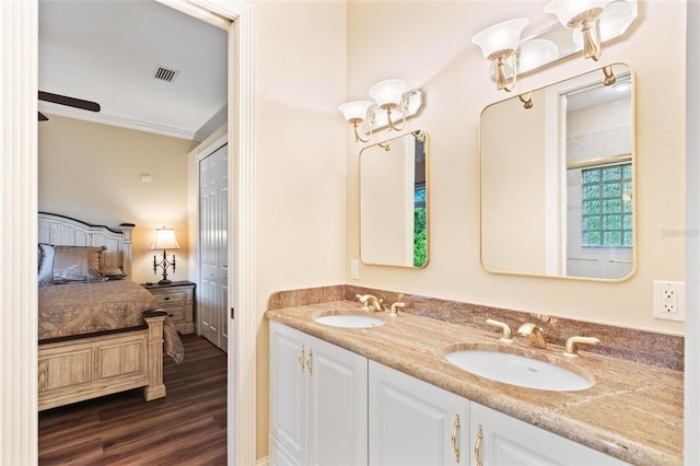 bathroom featuring ceiling fan, hardwood / wood-style floors, vanity, and ornamental molding