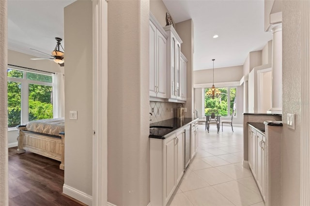 kitchen featuring white cabinets, pendant lighting, ceiling fan, and a healthy amount of sunlight