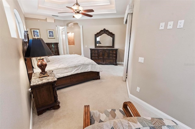 bedroom with light carpet, decorative columns, ornamental molding, a raised ceiling, and ceiling fan