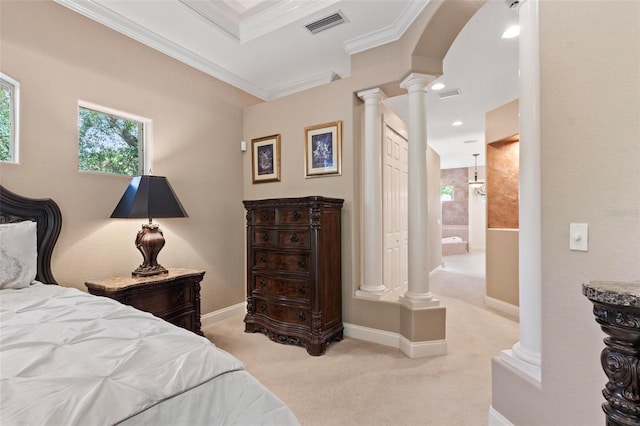 bedroom featuring ensuite bath, ornamental molding, light carpet, and ornate columns