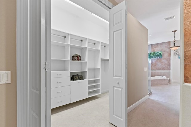 walk in closet featuring light carpet