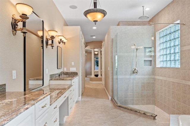 bathroom with tile patterned floors, vanity, and tiled shower