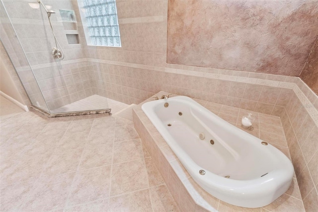 bathroom featuring tile patterned flooring, plus walk in shower, and tile walls