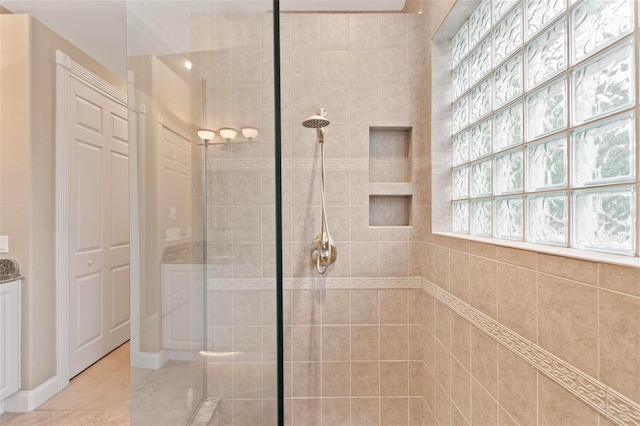 bathroom with a tile shower and tile patterned floors