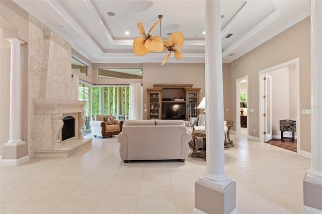 living room featuring a tray ceiling, ceiling fan, a fireplace, and light tile patterned floors