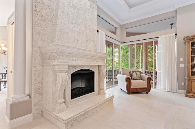 unfurnished living room featuring tile patterned floors, ornamental molding, a fireplace, and decorative columns