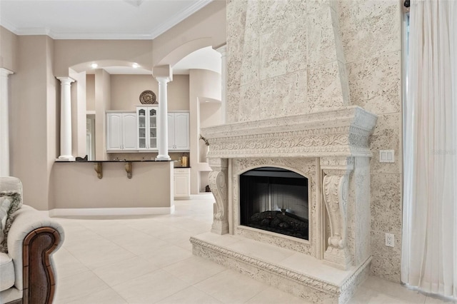 interior space with ornate columns, light tile patterned floors, tile walls, and ornamental molding