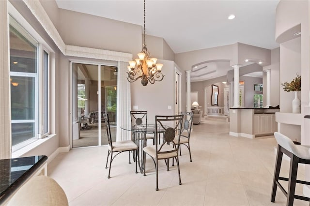 dining room with ornate columns, light tile patterned floors, and an inviting chandelier