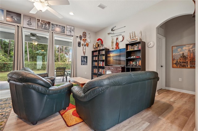 living room featuring ceiling fan and light hardwood / wood-style floors