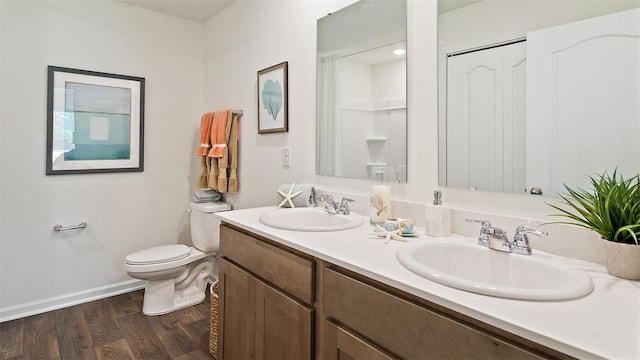 bathroom with a shower, hardwood / wood-style floors, vanity, and toilet