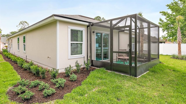 view of home's exterior featuring a lanai and a yard