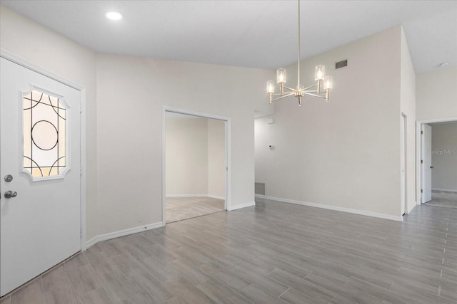 foyer entrance with a chandelier and light hardwood / wood-style flooring