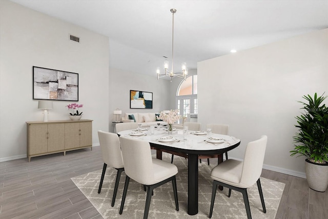 dining area with a notable chandelier and light wood-type flooring