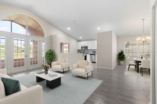 living room with lofted ceiling, wood-type flooring, french doors, and a chandelier