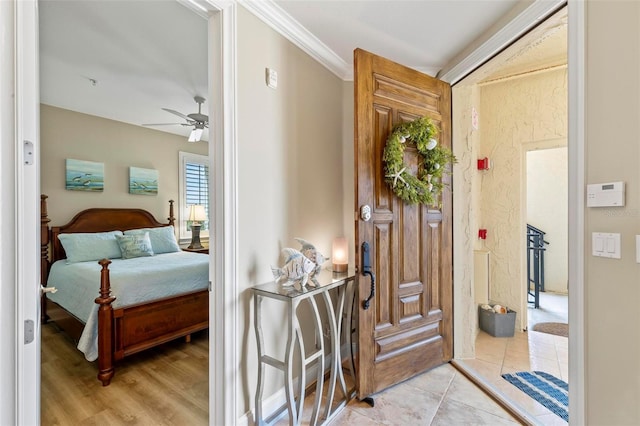 foyer with ceiling fan, light hardwood / wood-style floors, and ornamental molding