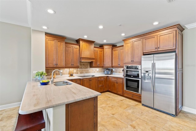 kitchen featuring kitchen peninsula, appliances with stainless steel finishes, a kitchen breakfast bar, custom range hood, and sink