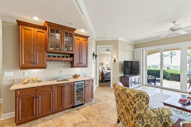 kitchen with ceiling fan, sink, beverage cooler, crown molding, and light tile patterned floors