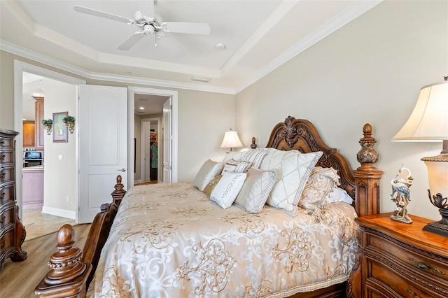 bedroom with a tray ceiling, ceiling fan, and ornamental molding