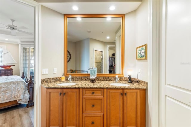 bathroom with wood-type flooring, vanity, and ceiling fan