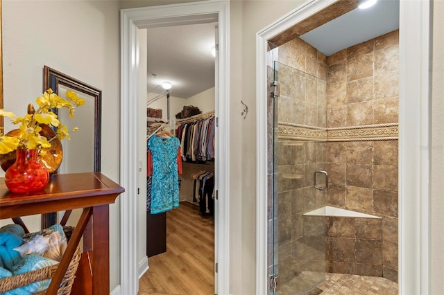 bathroom with hardwood / wood-style flooring and a shower with shower door