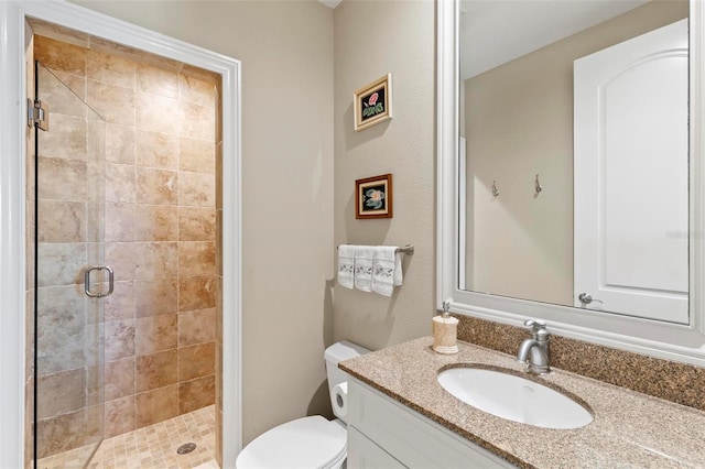 bathroom featuring vanity, an enclosed shower, and toilet