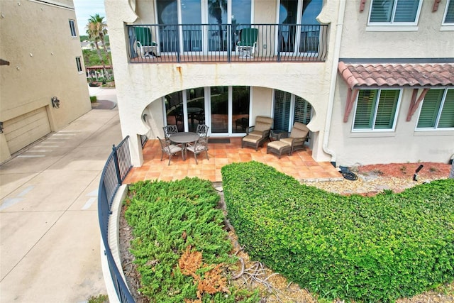 rear view of house with a patio and a balcony