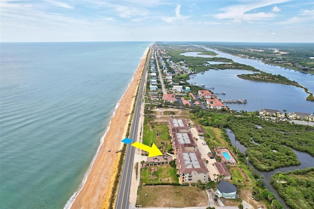 drone / aerial view featuring a water view and a view of the beach