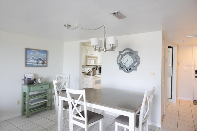 tiled dining area featuring a notable chandelier