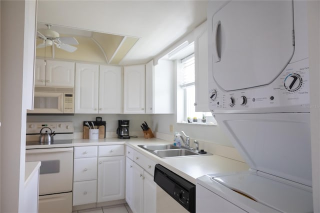 kitchen with ceiling fan, sink, stacked washer / dryer, white appliances, and white cabinets