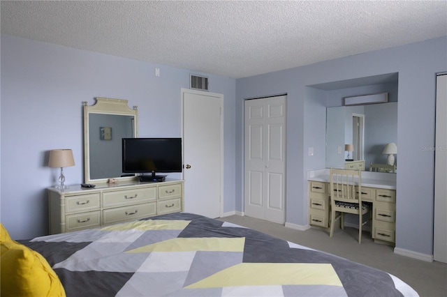 carpeted bedroom with a textured ceiling and a closet