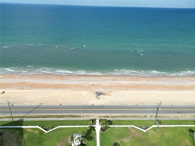 drone / aerial view with a water view and a beach view