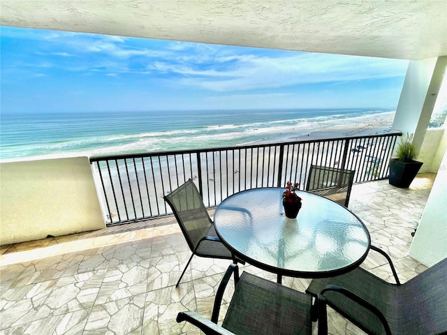 balcony featuring a beach view and a water view