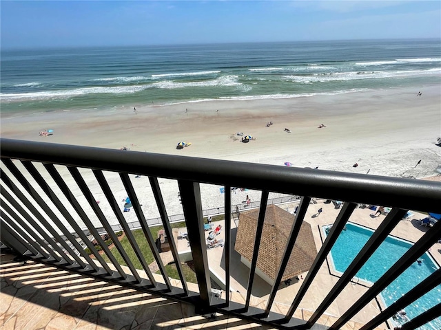 balcony with a water view and a beach view