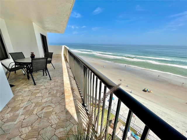 balcony featuring a water view and a view of the beach