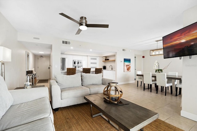 living room with ceiling fan, light tile patterned floors, and sink