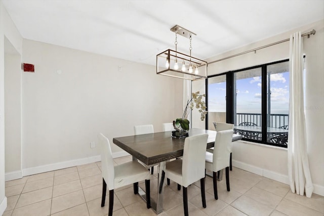 dining room featuring light tile patterned flooring and a water view