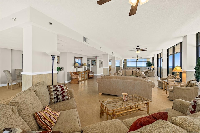 living room featuring ceiling fan and a textured ceiling