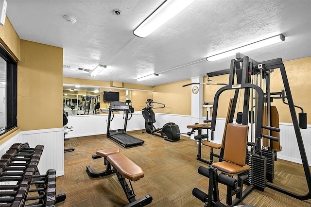 exercise room featuring carpet flooring and a textured ceiling