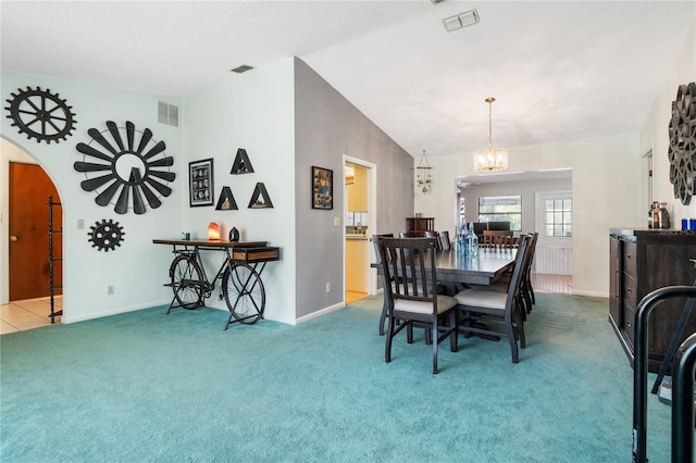 dining room with vaulted ceiling, an inviting chandelier, and carpet flooring