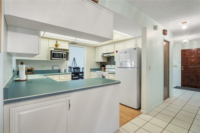 kitchen with white cabinetry, sink, kitchen peninsula, and white appliances