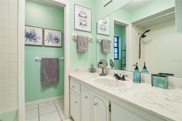 bathroom with vanity, tile patterned flooring, and a tile shower