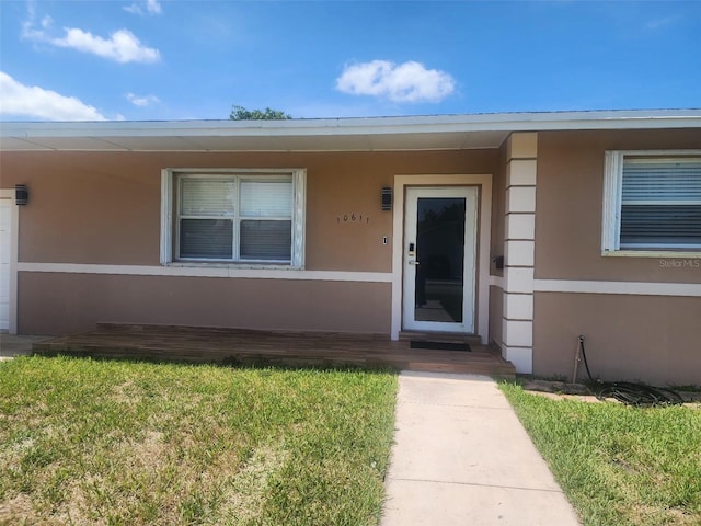10611 SW 164th St, Miami, FL 33157 - view of exterior entry featuring stucco siding and a lawn