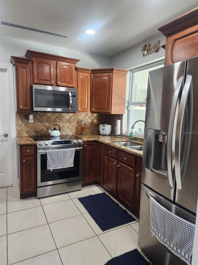 10611 SW 164th St, Miami, FL 33157 - kitchen featuring stainless steel appliances, a sink, backsplash, dark stone countertops, and light tile patterned floors