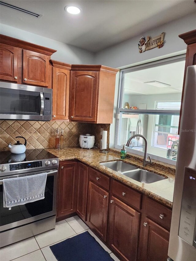 10611 SW 164th St, Miami, FL 33157 - kitchen with appliances with stainless steel finishes, a sink, light tile patterned floors, light stone countertops, and tasteful backsplash