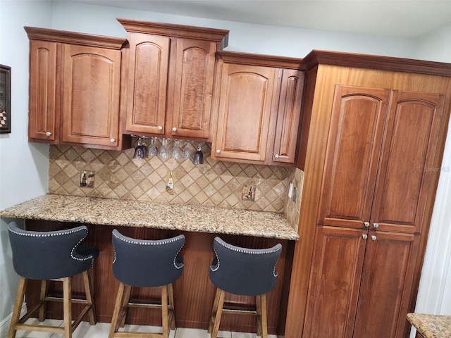 10611 SW 164th St, Miami, FL 33157 - kitchen featuring decorative backsplash, a breakfast bar, and light stone countertops