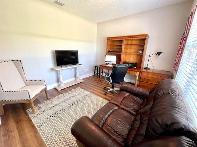 office with hardwood / wood-style floors and a textured ceiling