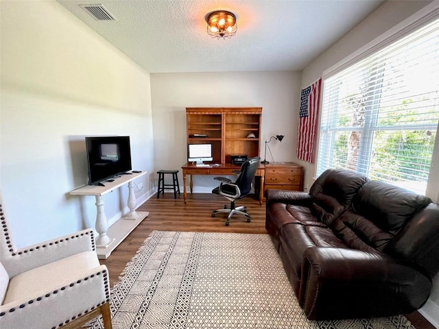 home office featuring hardwood / wood-style floors and a textured ceiling