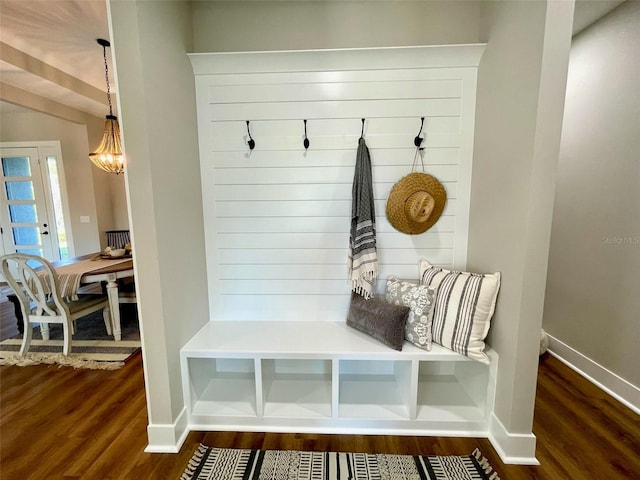 mudroom featuring dark wood-type flooring and a notable chandelier